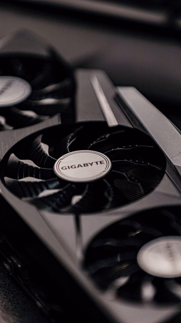 Contemporary specialized electronic black video cards with inscriptions for generating feed of output images to display device placed on table in room.