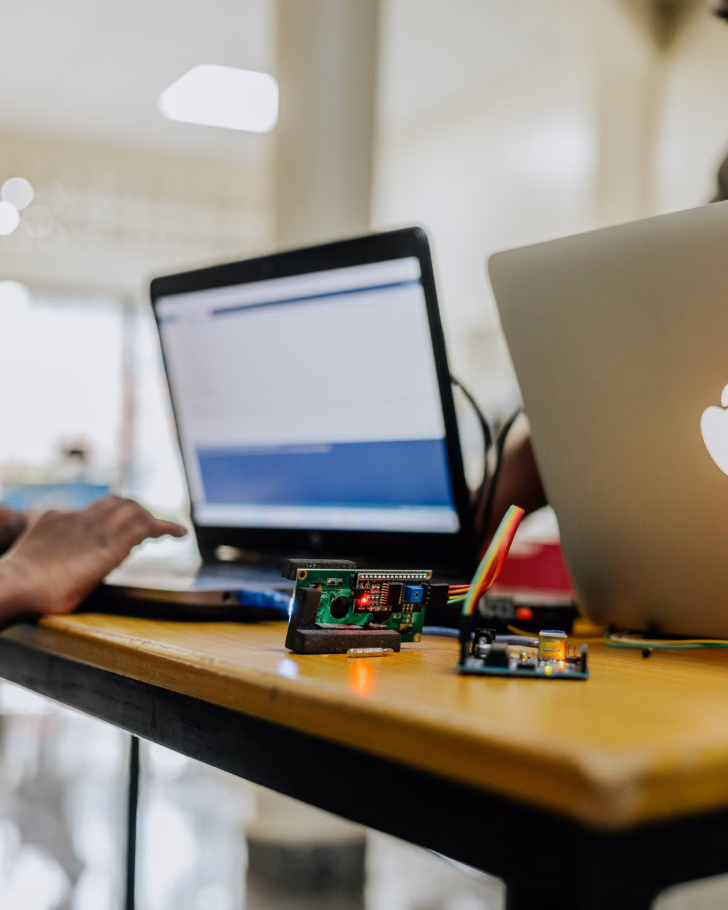 High-tech electronics and laptops on a workspace table indoors with blurred background.